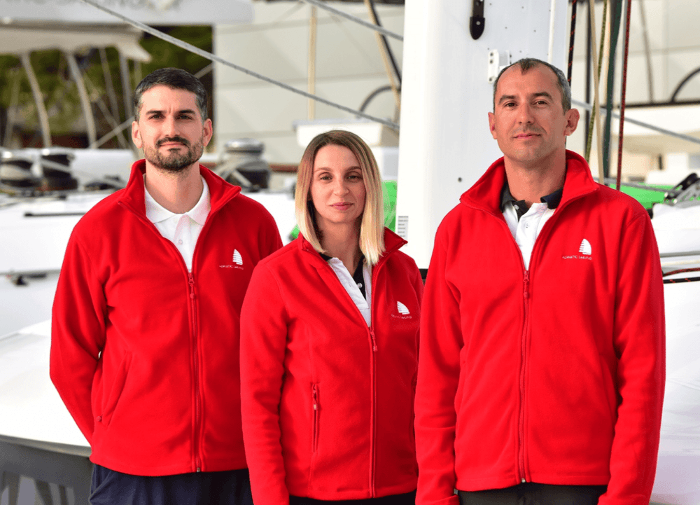 lion yacht crew three people in red