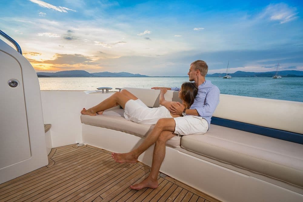 romantic sailing holiday couple sitting on deck sunset