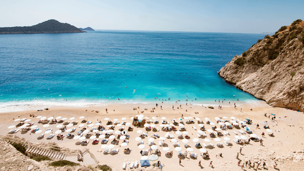tourists sunbathing and swimming on the kaputas beach, kas, antalya turkey