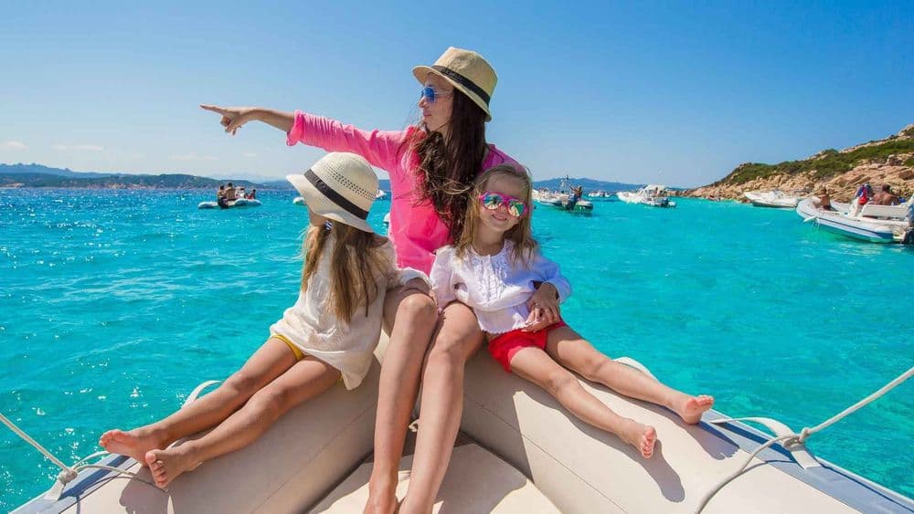 family sailing woman and kids in a dingy